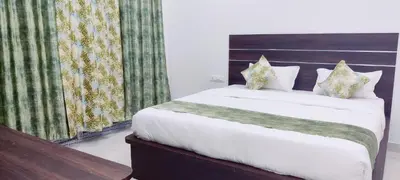 a bedroom with a large bed with white sheets at Suvarna Elite - Premium Apartment Hotel in Mysore