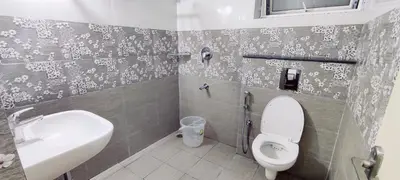 a bathroom with a toilet and a sink at Suvarna Elite - Premium Apartment Hotel in Mysore
