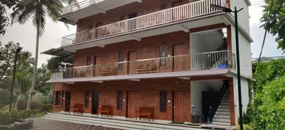 a building with balconies and tables on it at DOLPHIN ENCLAVE SERVICE STUDIO APARTMENTS in Kalpetta