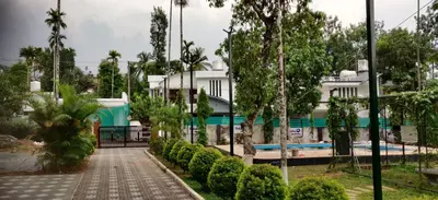 a house with a swimming pool and trees at DOLPHIN ENCLAVE SERVICE STUDIO APARTMENTS in Kalpetta