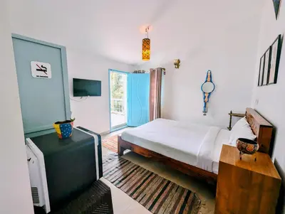 a bedroom with a bed and a large window at Bohemian Hideaway by Futurve in Kodaikānāl