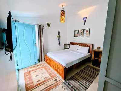 a bedroom with a bed and a blue door at Bohemian Hideaway by Futurve in Kodaikānāl