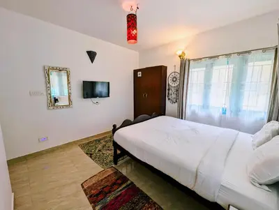 a bedroom with a large bed and a mirror at Bohemian Hideaway by Futurve in Kodaikānāl