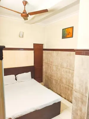 a bedroom with a bed with a ceiling fan at New AS Tourist Home Aluva in Cochin