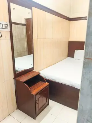 a small room with a mirror and a bed at New AS Tourist Home Aluva in Cochin