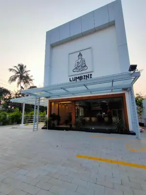 a large white building with a sign on it at Lumbini Supreme in Trichūr