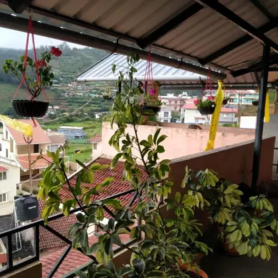 a balcony with potted plants and a view of a city at HAVEN COTTAGE in Ooty
