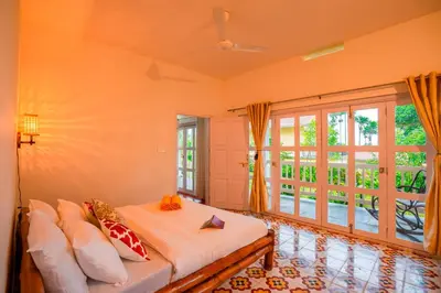 a bedroom with a bed and a large window at Zostel Homes Wayanad, Karapuzha in Wayanad