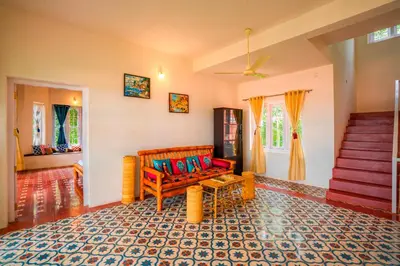 a living room with a bench and a staircase at Zostel Homes Wayanad, Karapuzha in Wayanad