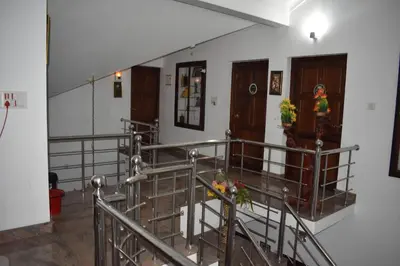 a staircase with metal railing in a building at Ben's Villa Kannur ! in Kannur
