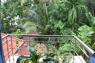 a view of a garden from a balcony at Ben's Villa Kannur ! in Kannur