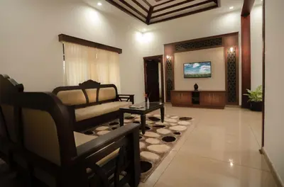 a living room with a couch and a table at Wayanad Mace Mansion in Kenichira