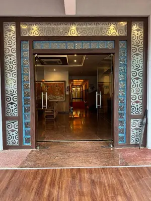 an open glass door into a living room at GD International Redfort in Nilambūr