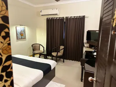 a hotel room with a bed and a desk and a tv at GD International Redfort in Nilambūr