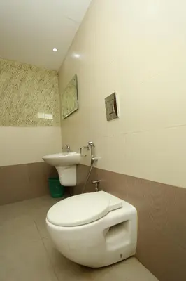 a bathroom with a toilet and a sink at Hotel Innate Inn in Alwaye