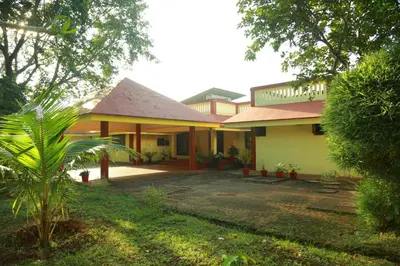 a house with a courtyard in front of it at KTDC Tamarind Kondotty in Kondotti