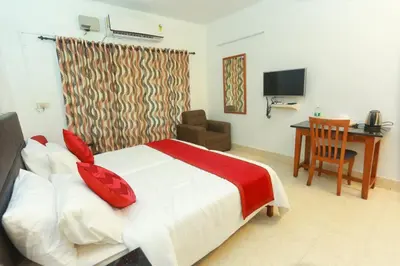 a bedroom with a bed and a desk and a television at KTDC Tamarind Kondotty in Kondotti