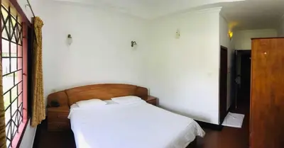a bedroom with a white bed in a room at KTDC Tamarind Kondotty in Kondotti
