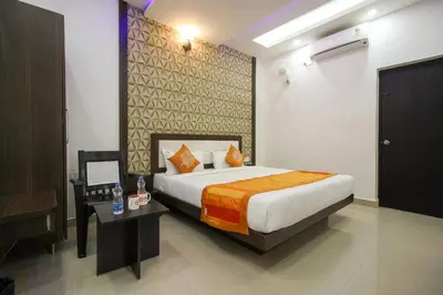 a hotel room with a bed and a desk and a bed sidx sidx at OYO Flagship 8281 Aj Palace in Mysore