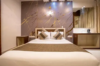 a bedroom with a large bed and a wall at Aishwarya Suites in Mysore
