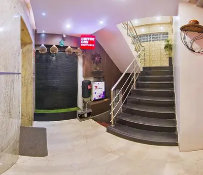 a spiral staircase in a building with a sign on the wall at Aishwarya Suites in Mysore