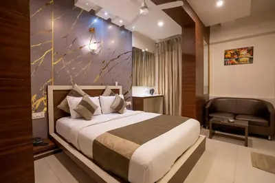 a hotel room with a bed and a chair at Aishwarya Suites in Mysore