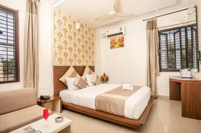 a hotel room with a bed and a couch at Aishwarya Suites in Mysore