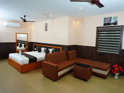 a bedroom with a bed and a couch in it at ABUDHABI RESIDENCY in Palakkad