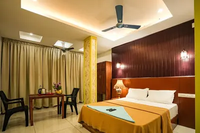 a hotel room with a bed and a table and chairs at Melanna Cherai Beach in Cherai Beach