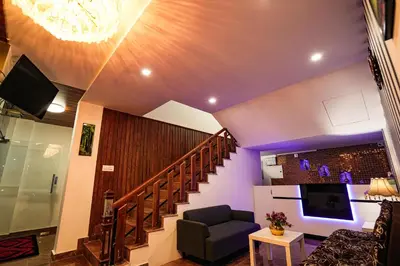 a living room with a staircase and a tv at Melanna Cherai Beach in Cherai Beach