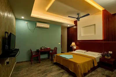 a bedroom with a bed and a table with a television at Melanna Cherai Beach in Cherai Beach