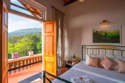 a bedroom with a bed and a large window at Zostel Homes Wayanad, Vythiri in Wayanad