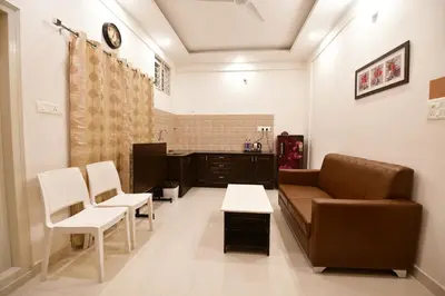 a living room with a couch and a table and chairs at Xcel Luxury Hotel Apartments-Home Living Redefined in Mysore