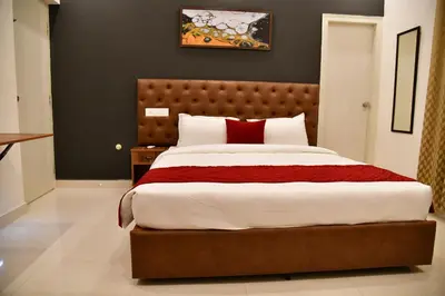 a bedroom with a large bed with red pillows at Xcel Luxury Hotel Apartments-Home Living Redefined in Mysore