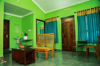 a living room with green walls and a table and a chair at Puzhayoram home stay, Palakkuli, Mananthavadi wayanad kerala in Mananthavady