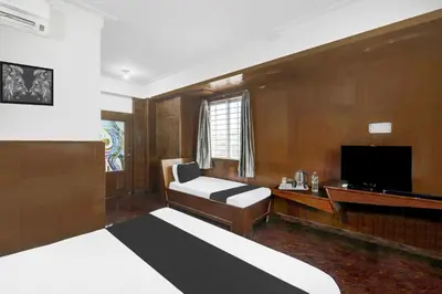 a hotel room with a bed and a television at Super Townhouse Mysore City Centre Formerly Hotel Mahendra in Mysore