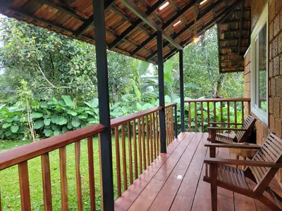 a wooden porch with two benches on a house at Aalterra by The Almanac in Wayanad