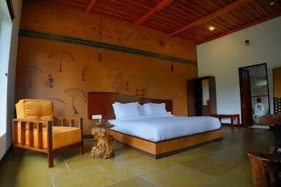 a bedroom with a bed and a chair at Aalterra by The Almanac in Wayanad