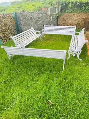 two white benches sitting in a field of grass at S ELLA Residency in Kotagiri