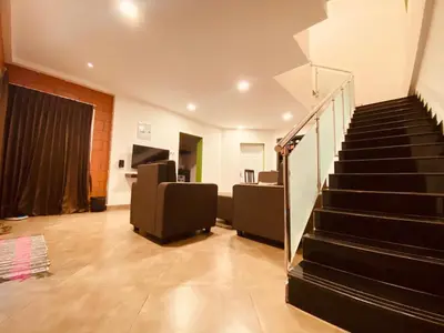 a room with a staircase with a couch and a stair case at S ELLA Residency in Kotagiri