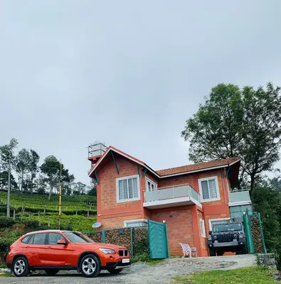 a red car parked in front of a house at S ELLA Residency in Kotagiri
