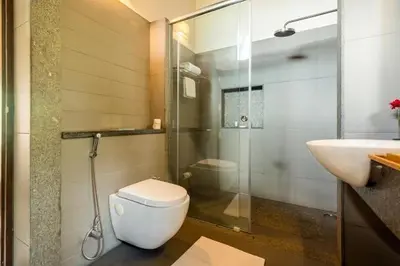 a bathroom with a toilet and a sink and a shower at amã Stays & Trails - The Old Cattleshed, Wayanad in Wayanad
