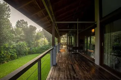 a porch of a house with a view of a garden at amã Stays & Trails - The Old Cattleshed, Wayanad in Wayanad
