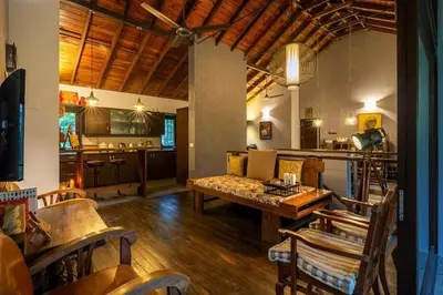 a living room with a couch and a table at amã Stays & Trails - The Old Cattleshed, Wayanad in Wayanad