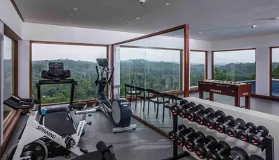 a fitness room with a gym with a view at GReaT Trails Wayanad by GRT Hotels in Wayanad