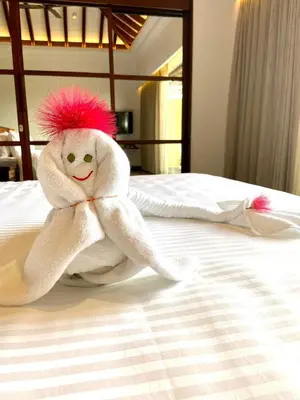 a stuffed towel animal sitting on a bed at GReaT Trails Wayanad by GRT Hotels in Wayanad
