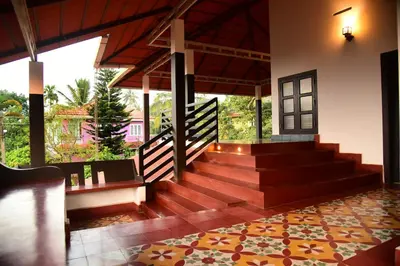 a lobby with stairs and a cross on the wall at Nivaasana Bed & Breakfast in Kalpetta