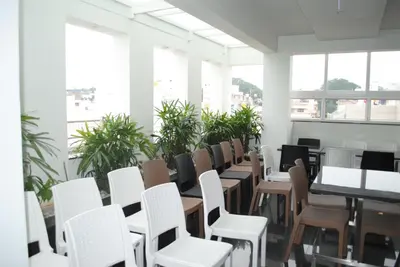 a row of tables and chairs in a room with plants at Mysore Royale in Mysore