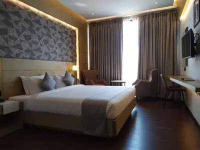a hotel room with a bed and a television at MothiMahal Residency Thrissur in Trichūr