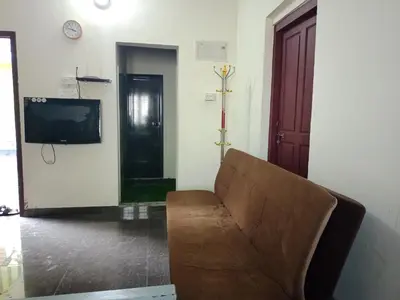 a living room with a couch and a tv at Kalamana Serene in Chāvakkād